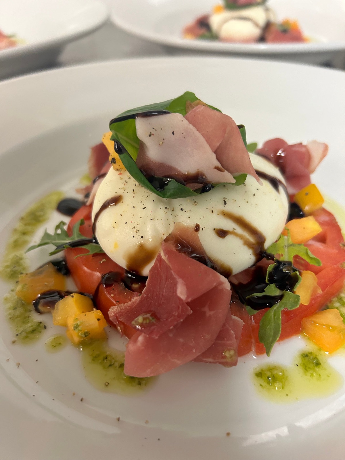 Plated burrata and tomato course