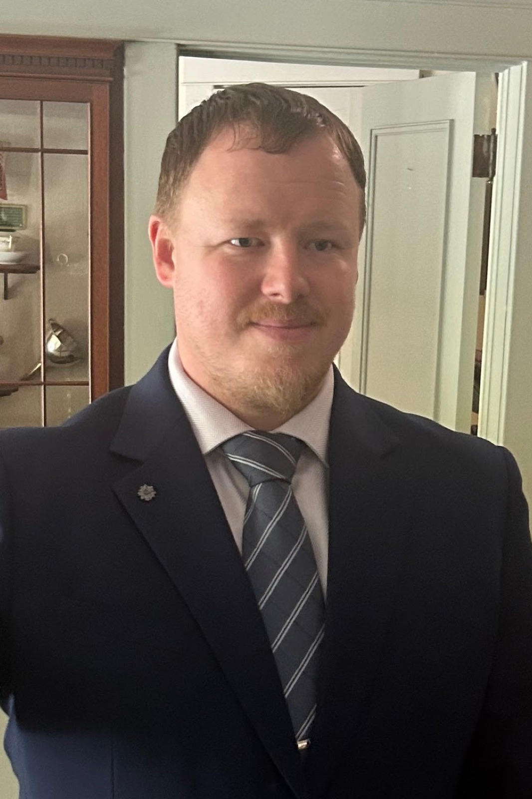 Tyler Raynham in a navy suit and tie