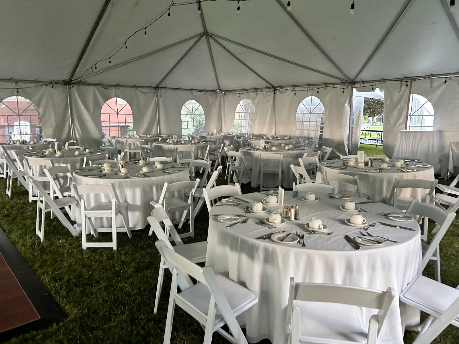 Round tables set under a white wedding marquee tent